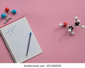 Chemical molecular models in representation of some organic molecules with lewis representation of ethanol on a notebook.