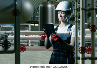 Chemical Production. Woman Engineer At Chemical Factory. Girl In Protective Helmet Among Pipes. Pipes And Tanks Inside Chemical Factory. Woman Engineer At Modern Factory. Art Focus. Lady With Tablet