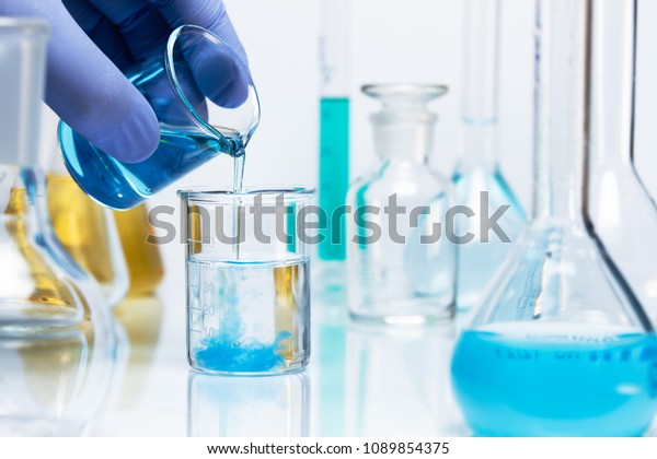 Chemical reaction. Blue precipitate\
is formed in a beaker as a result of a chemical reaction.\
