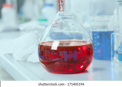 A chemical round bottom flask with a red Liquid.