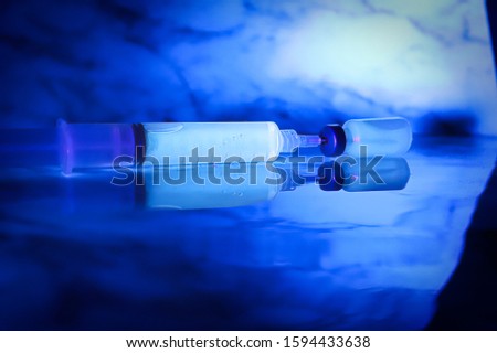 Chemicals glowing under blacklight against a blue background