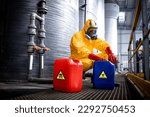 Chemicals industry for acid production. Factory worker in hazmat protective suit and gas mask carefully working with hazardous materials.