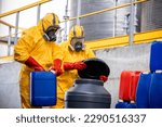 Chemicals manufacture. Workers in protective chemical suit and gas mask dealing with dangerous or hazardous materials and acids.