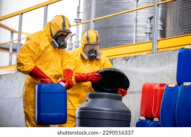 Fabricación de productos químicos. Trabajadores con traje químico protector y máscara de gas que se ocupan de materiales y ácidos peligrosos o peligrosos.