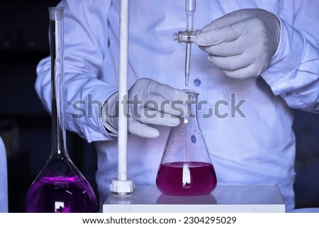 The chemist conducts acid-base titration and adding solutions