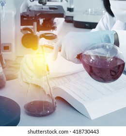 Chemist holding sample of liquid in lab or laboratory