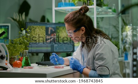 Chemist injecting vegan beef meat with protein using medical syringe for microbiology experiment. Biochemist woman researching vegetareian food modified genetically working in chemistry laboratory