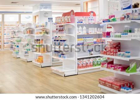 At the chemist, Medicines arranged in shelves, Pharmacy drugstore retail Interior blur abstract background with medicine healthcare product on cabinet with neon light.