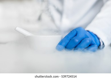 Chemist performs an experiment with liquid nitrogen in laboratory mortar with pestle - Powered by Shutterstock