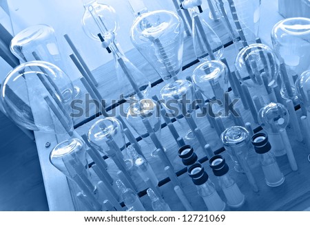 Chemistry lab glassware on a drying rack - blue monochrome