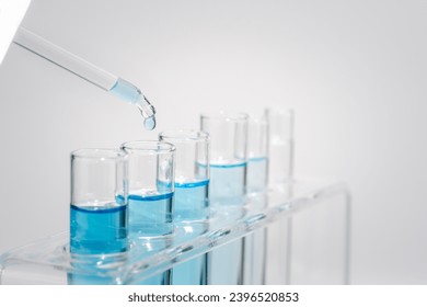 Chemistry laboratory tube glass, science laboratory research and development concept, flask, beaker, and test tubes with dropping blue liquid water sample test, scientific test tubes equipment.