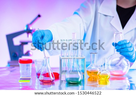 Chemistry. Mixing of chemical reagents. Chemist. A man works in a laboratory. Checking chemical reactions. Organic chemistry. Laboratory synthesis. A human mixes liquids. Career chemist.