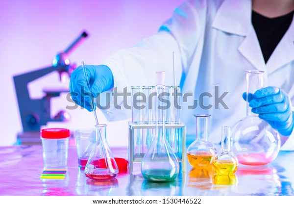 Chemistry. Mixing of chemical reagents. Chemist.\
A man works in a laboratory. Checking chemical reactions. Organic\
chemistry. Laboratory synthesis. A human mixes liquids. Career\
chemist.