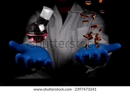 Chemistry round bottom flask and transparent pills dropping on a human scientist hand with black background copy space. Medicinal chemistry red chemical solution and chemical biology.