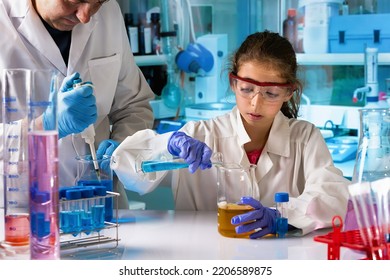 chemistry student girl with scientific material doing science experiments in technology class at school. Student girl testing chemical experiment in elementary school laboratory chemistry classroom - Powered by Shutterstock