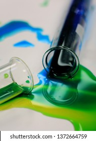 Chemistry Test Tube Spill With Colors Green, Blue And Yellow On A White Background