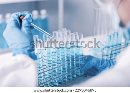 chemist,scientist hand dropping chemical liquid into test tube, science research and development concept