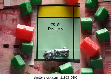 CHENGDU, CHINA - 19th Aug 2022: Dalian City Property Field With Green Houses And Chinese Yuan Paper Notes On Monopoly Boar Game, Illustrating The Housing Market.