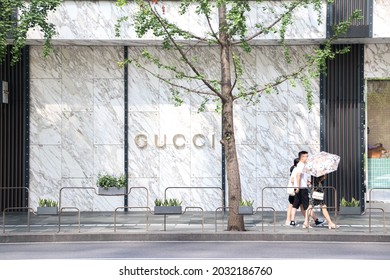 Chengdu, China - 21st August 2021: A Family Walks Pass The Gucci Store In Chengdu Tai Kooli, Lady Holding Parasol, Umbrella In The Sun