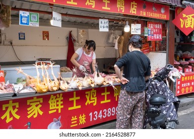 Chengdu, Sichuan, China - May 28 2022: A Stall Owner Is Carving Up Chickens For A Customer.