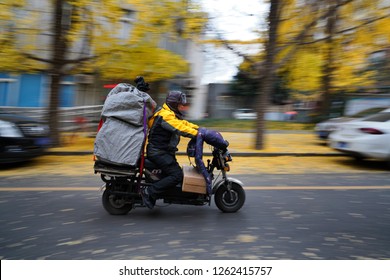 Chengdu, Sichuan / China - October 02 2018: A Delivery Man Passing By A Street In Chengdu In Fall. Delivery Becomes A Popular Job In China Due To Large Demand Of ECommerce. 