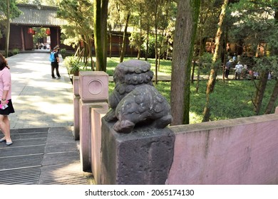 Chengdu, Sichuan, China - September 29 2021: Cute stone lion dog butt at Wu Hou Shrine with fluffy cloud pattern for fur, a little wiggly tail, and small anus hole on fence post.