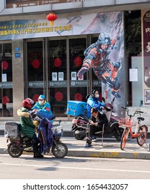 Chengdu,Sichuan/China-February 19, 2020:Two Delivery Men Passed A Downtown Movie Theater That Had Been Closed For A Month Because Of The Outbreak.