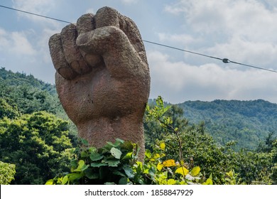 Cheongyang-gun, South Korea; October 2, 2020: For editorial use only. Statue of raised clenched fist in wilderness underbrush.