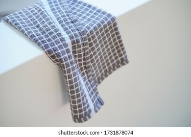 Chequered Tea Towel On A White Quartz Worktop. 