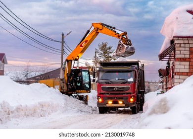 Cherepovets, Russia, February 15, 2022, Snow Clearing Of Utility Services  On City Streets In Winter After A Snowstorm Or Snowfall.Excavator Loads Snow Into Truck. 