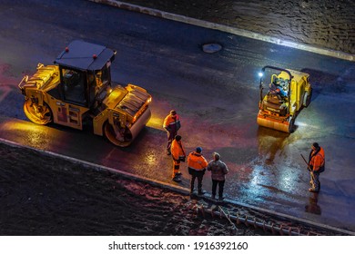 Cherepovets Russia November 13, 2020 Workers Perform Road Work On Laying Asphalt On A City Street At Night. Road Construction. Rolling Paver At Night With Headlights.