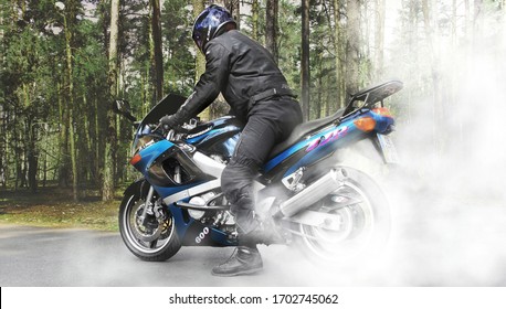 Chernihiv, Ukraine - April 7, 2020: A motorcyclist on a motorcycle on the road. Burnout. Motorcycle burns rubber. Kawasaki
