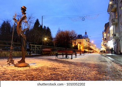 Chernivtsi, Ukraine - December 21, 2017: Sculpture Of A Janitor On Pedestrian Street Of Olga Kobylianska In Central Chernivtsi, Ukraine At Night.