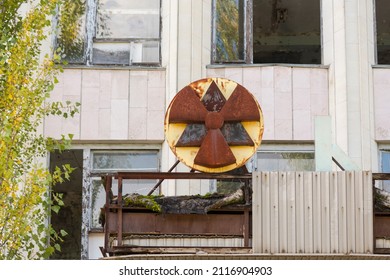 Chernobyl, Ukraine - September 26, 2021: Old metal rusty radiation sign above the entrance to the abandoned laboratory building.