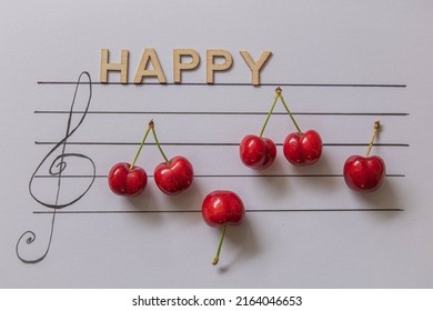 Cherries And Music Notes On White Background And Wooden Words Happy