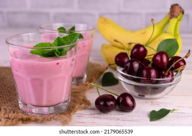 Cherry And Banana Smoothie On A White Wooden Background.
