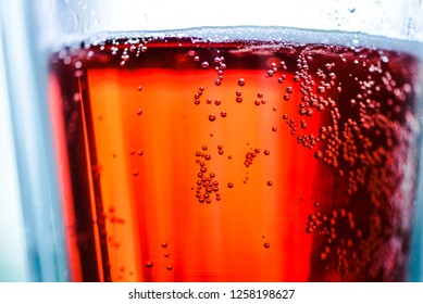 Cherry beer with bubbles in a glass beaker. Photo for design, advertising, banners, beer festival, October fest, posters, prints. Glass mug of tasty fruit beer macro. Liquid texture closely.