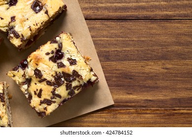 Cherry Blondie Or Blond Brownie Cake Baked With White And Dark Chocolate, Photographed Overhead With Natural Light (Selective Focus, Focus On The Top Of The Cake Pieces)