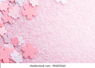 Cherry blossom background image. Cherry blossom pastel pink abstract background fading in to white. Sakura or cherry flower shaped paper cutouts on pink background. 