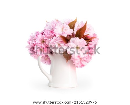 Cherry blossom in vase or jug. Isolated flower bouquet used as table center piece for weddings, parties, events or sakura spring decoration.  Pink flowers from Kwanzan cherry tree. Selective focus.