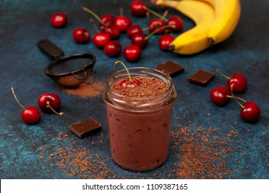 cherry chocolate smoothie (black forest) in a jar on a dark blue background