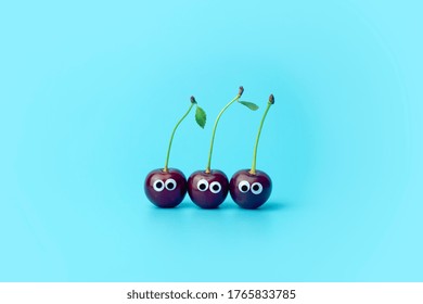 Cherry with eyes on a blue background. Funny vegetables and fruits for children. Baby food concept,  food face. - Powered by Shutterstock