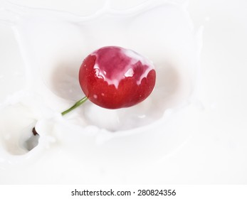 cherry falling into milk