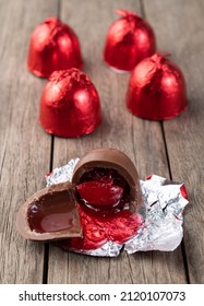 Cherry Filled Chocolate Candy With Candies Packed In Red Foil Paper.