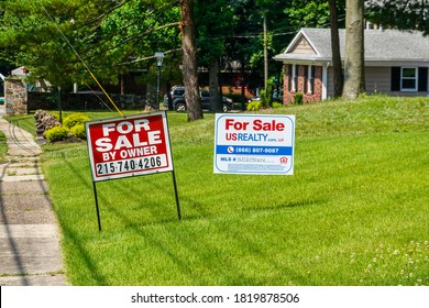 Cherry Hill, New Jersey - August, 2020: A Green Lawn In Front Of A House With Two For Sale Signs Seen On A Sunny Day