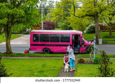 Cherry Hill, New Jersey - July, 2020: A Pink School Bus Used As A Dog Grooming Spa Parked On A Street In Front Of A House With The Groomer Talking To The Dog Owner