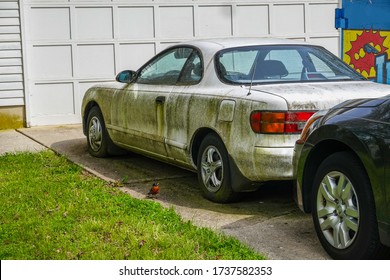 Cherry Hill, New Jersey - May, 2020: An Extremely Dirty White Car Was Seen Parked In A Driveway By A Multi-panel Garage Door