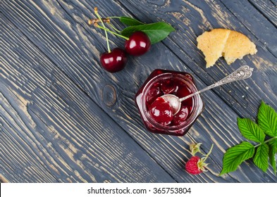 Cherry Jam And Raspberry In Glass Jars On Wooden Table. Top View