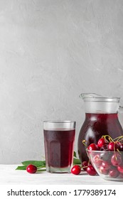 Cherry Juice In A Glass And Jug With Fresh Berries On White Background. Refreshment Summer Drink. Healthy Drink. Vertical Orientation