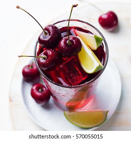 Cherry Limeade, Lemonade, Cola, Cocktail In A Tall Glass On A White Plate.
Close Up.
